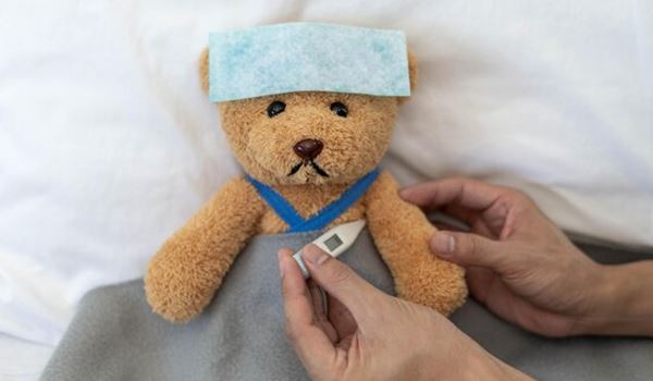 teddy bear with thermometer and cold compress