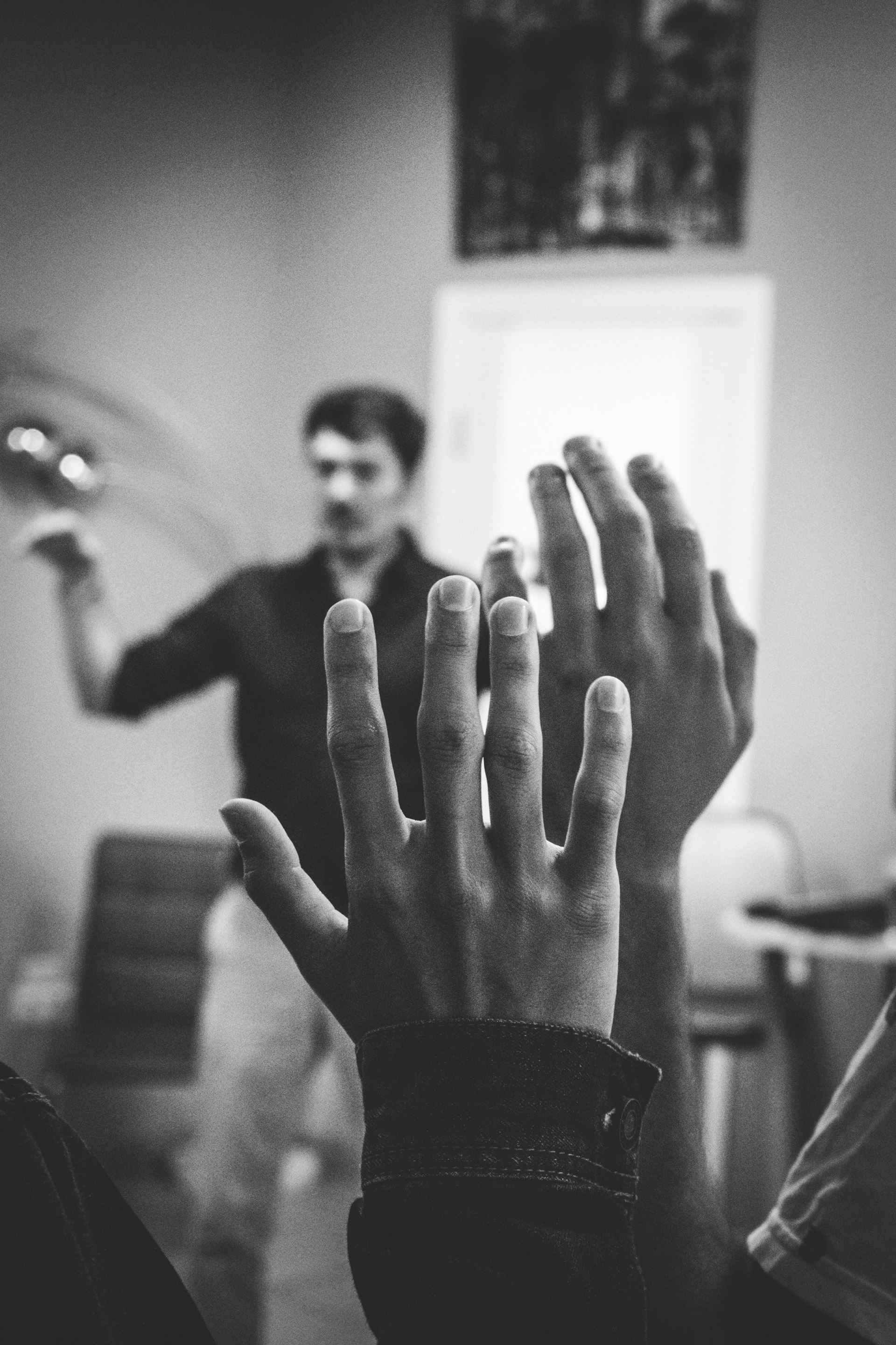 black and white photo of hands being raised in the air